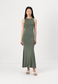 Robe maxi ajustée vert foncé avec un design sans manches, en tissu lisse, jupe fluide et légère évasement à l'ourlet.