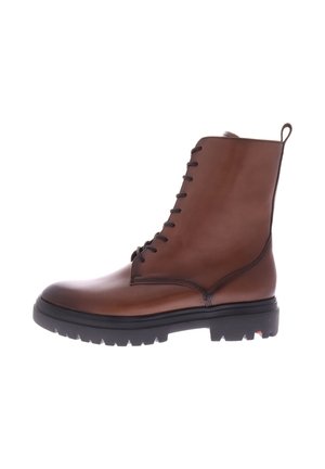 Brown leather ankle boot with a smooth finish, round toe, lace-up front, pull tab, and rugged black rubber sole featuring textured grip.