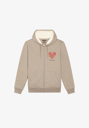 Felpa beige con zip e interno morbido e peloso, con una grafica a forma di cuore rosso e il testo "SWEET" sottostante. Include due tasche laterali.