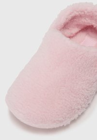 Rosa Fleece-Slipper mit einer weichen, strukturierten Oberfläche. Geschlossene Zehenpartie, runde Form mit einem gepolsterten Innenfutter für zusätzlichen Komfort.