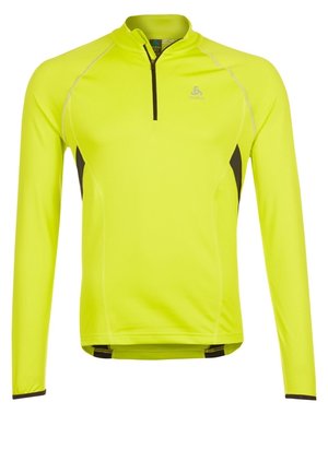 Neonowo żółta sportowa koszulka z długim rękawem, czarnymi bocznymi panelami i krótkim czarnym zamkiem przy kołnierzu.