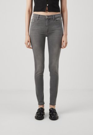 Jeans skinny grigi con una finitura sbiadita, tessuto in denim elasticizzato, due tasche anteriori, chiusura con bottone e zip, e una silhouette aderente.