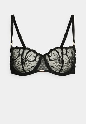 Black bra with floral lace details, sheer overlay, scalloped edges, and adjustable straps. Features gold-tone hardware at the center.