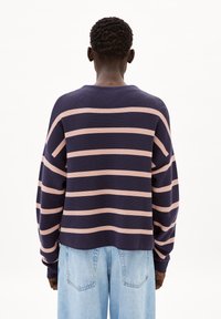 Marineblauw en roze gestreepte trui met een relaxte pasvorm, lange mouwen, geribbeld textuur en een ronde halslijn, gecombineerd met lichtblauwe denim broek.