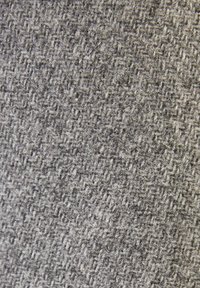 Texturerad grått tyg med ett vävt mönster som har subtila variationer i nyans och en mjuk, något fluffig textur.