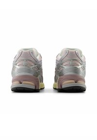 Achteraanzicht van grijze en roze hardloopschoenen. Kenmerken zijn onder andere een mesh materiaal, metalen accenten, een stevige zool en een licht gestructureerde afwerking.
