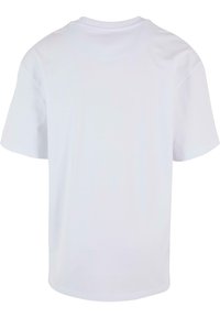T-shirt blanc en coton avec un col rond, des manches courtes et un ourlet droit. Le dos est uni, sans motifs ni logos visibles.