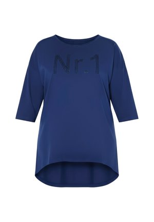 Sininen naisten toppi, jossa on kolme neljäsosaa hihaa, korkeampi ja matalampi helma sekä musta niitattu teksti "Nr.1" edessä.