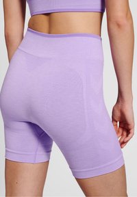 Shorts sportivi di color lavanda con una texture liscia, vita alta e design senza cuciture. Presentano motivi sottili e una silhouette aderente.
