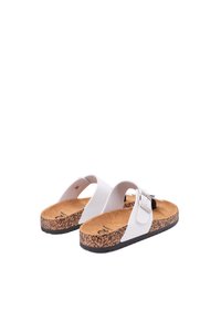 Sandali bianchi con suola in sughero, suola in gomma e una singola cinghia regolabile con fibbia argentata. Design piatto adatto per un abbigliamento casual.