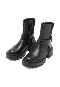 Stivaletti neri alla caviglia in pelle liscia e tessuto con cerniera laterale, dettaglio cinturino, suola spessa a zeppa e tacco con texture.