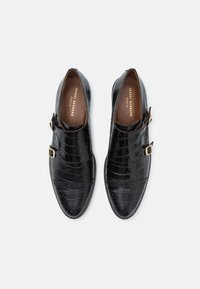 Schwarze Lederschuhe mit Krokodilprägung, glatter Textur, runder Zehenform und goldener Schnalle an der Seite.