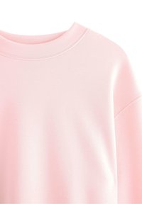 Vaaleanpunainen sweatshirta, jossa on pyöreä kaula-aukko, pehmeä rakenne ja rento leikkaus, näkyvillä ompeleilla kauluksessa ja hihoissa.