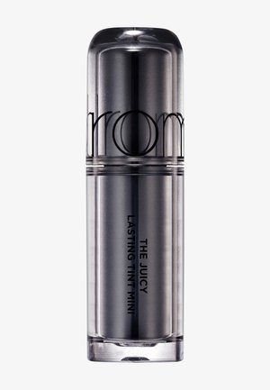 Sølvmetal cylindrisk beholder mærket "The Juicy Lasting Tint Mini" med en rundet hætte, sat mod en ensartet lys baggrund.