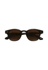 Lunettes de soleil noires avec des verres ronds marron, une épaisse monture et un léger détail découpé entre les verres. Présente deux petits points décoratifs.