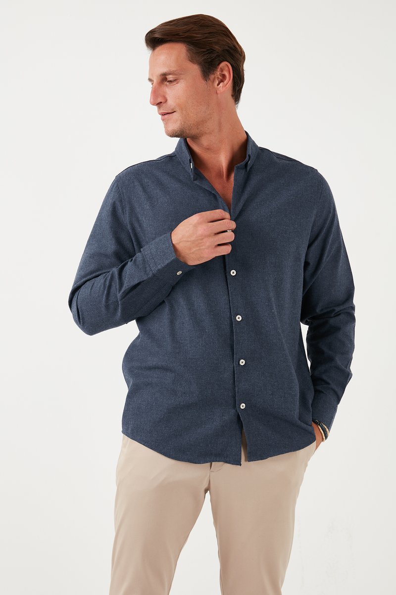 Camicia blu navy con bottoni, realizzata in tessuto testurizzato, con colletto a punta e maniche lunghe, dotata di bottoni bianchi e vestibilità sartoriale.