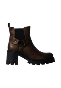 Bottine en cuir marron avec panneaux latéraux élastiques noirs, bride décorative à clous métalliques et talon bloc épais avec semelle à crampons.