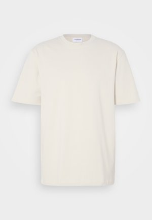 Rövid ujjú, off-white színű póló, pamutból készült. Klasszikus kerek nyakú dizájn, egyenes szabással és minimális varrási részletekkel.