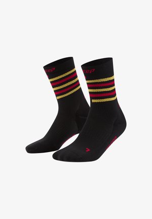 Schwarze Sportsocken mit roten und goldenen horizontalen Streifen. Verfügt über verstärkten Zehen- und Fersenbereich, elastischen Bund und Markenlogo in Pink.