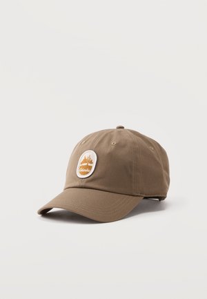 Braune Baseballkappe mit gebogenem Schirm und einem runden Aufnäher, der eine Wüstenszene zeigt, sowie dem Wort „Columbia“ auf der Vorderseite.