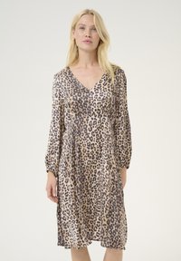 Rochie cu imprimeu leopard dintr-un material moale, având decolteu în V, mâneci lungi cu volane și o fustă fluidă care ajunge până la jumătatea gambei. Tonuri neutre predomină.