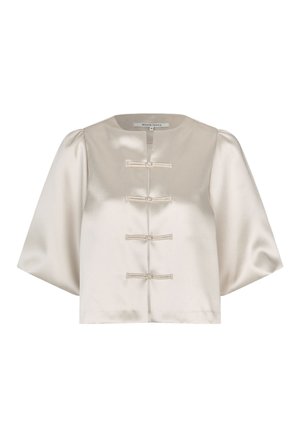 Blouse en satin crème avec un col rond, trois boutons décoratifs et larges manches. Texture lisse et coupe courte.