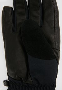 Svart läderhandske med en texturerad yta, med en svart fleecehandflata och marinblå accenter, snug elastisk handled och justerbar rem.