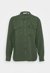 Langærmet grøn skjorte i let stof med knapper foran, klassisk krave og to brystlommer. Lommerne har lapper som detaljer.