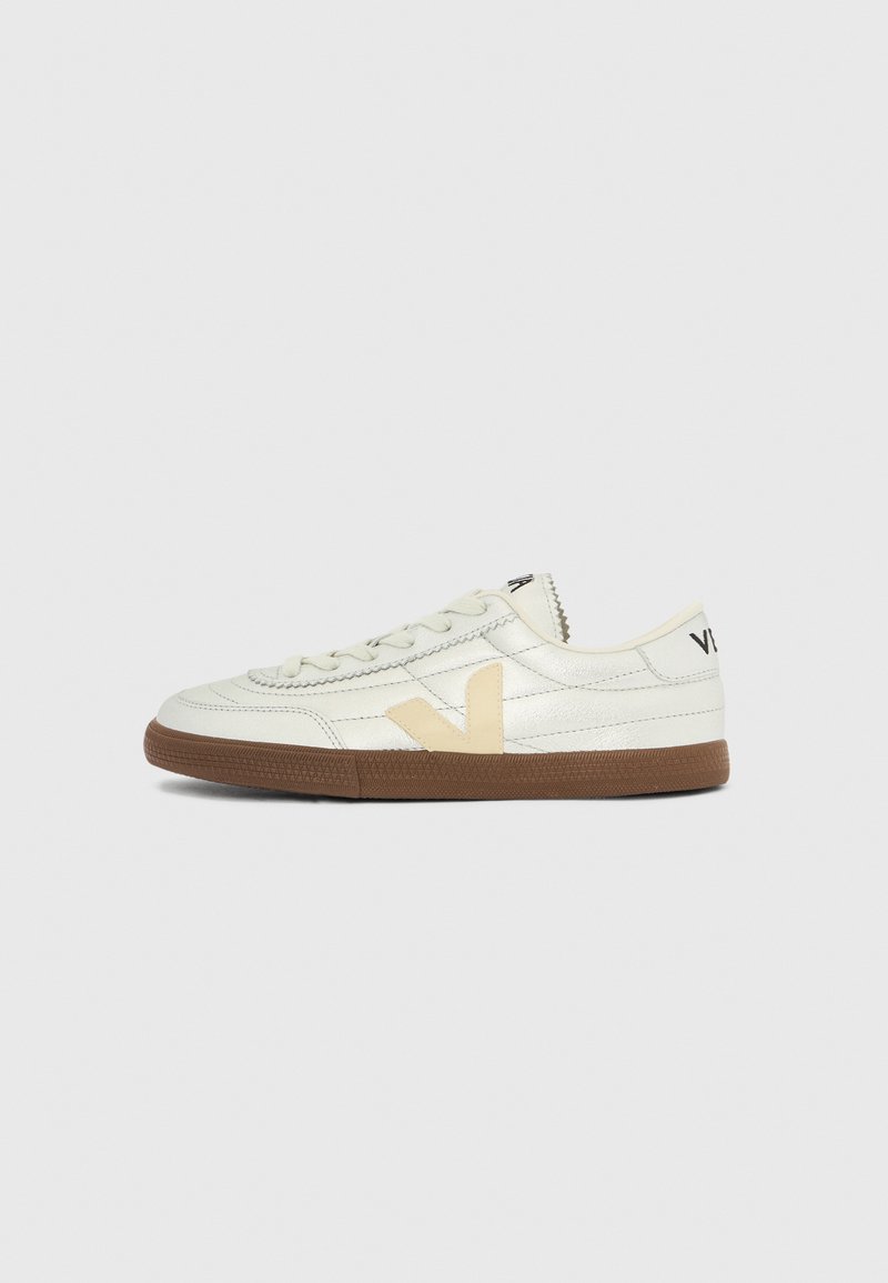 Scarpa da ginnastica bassa color crema con logo "V" beige, dettagli cuciti, suola marrone chiaro e testo nero sul tallone e sul lato della linguetta.