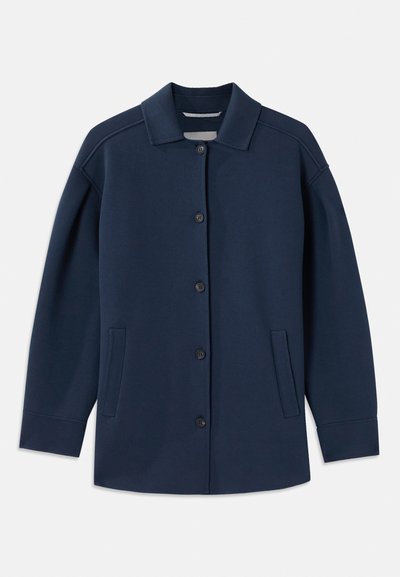 Tumesinine jakkk, millel on krae, ees nupud, küljetaskud ja lõdvestatud istuvus laiate varrukatega. Valmistatud pehmest kangast.