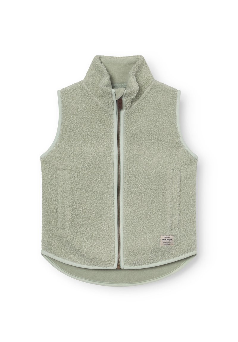 Svetlo zelena flis brezrokavnik z visokim ovratnikom, sprednjo zadrgo, dvema stranskima žepoma in majhno tkanino etiketo blizu spodnjega roba.