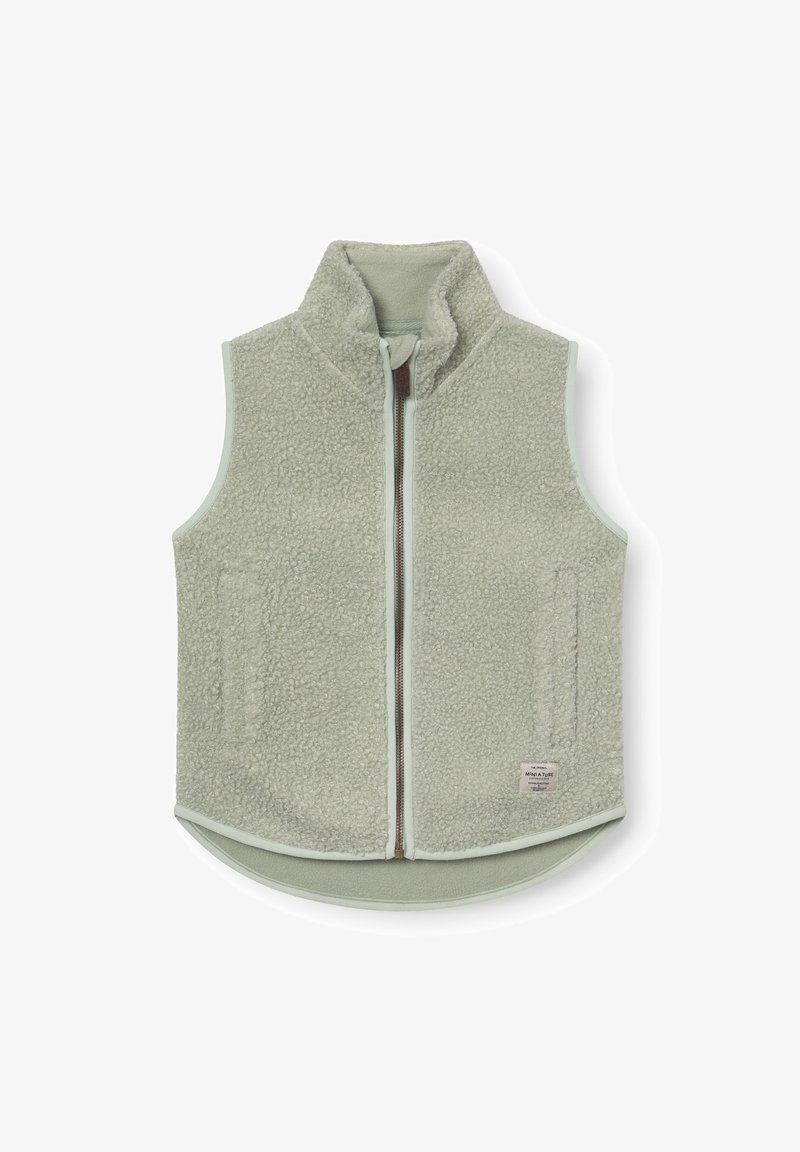 Svetlo zelena flis brezrokavnik z visokim ovratnikom, sprednjo zadrgo, dvema stranskima žepoma in majhno tkanino etiketo blizu spodnjega roba.