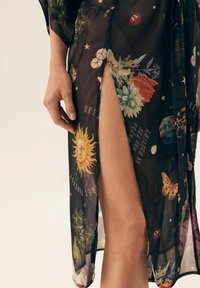 Przezroczysty czarny kimono z kwiatowymi i niebiańskimi wzorami, z akcentami motyli i motywów słońca oraz z wysokim rozcięciem na udzie.