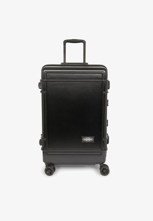 Maleta rígida negra con textura cepillada vertical, asa retráctil, cuatro ruedas y detalle de logo en el frente.