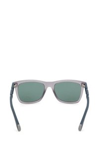 Occhiali da sole con una montatura traslucida grigia chiaro, lenti verdi e stanghette blu. Caratteristiche notevoli includono dettagli in metallo sulle cerniere.