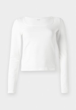 White long-sleeve fitted top with a square neckline and slightly cropped length, displayed against a white background.