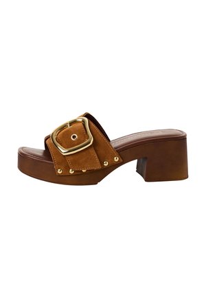 Sandales à talons carrés en daim marron avec une large bride, une grande boucle en or et des accents de clous contrastants. Semelle marron lisse.