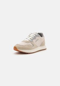 Lightweight sneaker in beige and gray, featuring a suede upper, textured accents, white laces, and a rubber outsole.