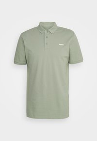 Polo uni vert clair à manches courtes avec trois boutons et petit logo blanc "HUGO" sur le côté gauche de la poitrine.