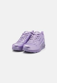 Sneaker sintetici viola con finitura lucida, dotate di suola ammortizzata, design con lacci e logo sulla linguetta.