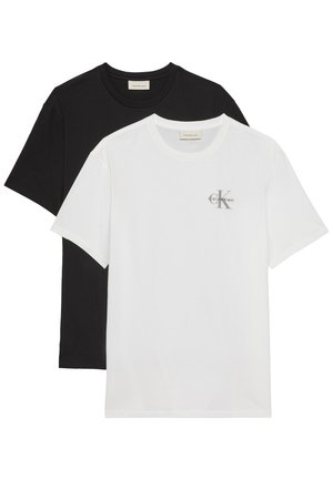 Dva složena T-shirt majice s okruglim izrezom, jedna bijela s malim Calvin Klein logotipom na prsima, a ispod nje obična crna.