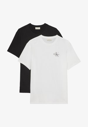 Dva složena T-shirt majice s okruglim izrezom, jedna bijela s malim Calvin Klein logotipom na prsima, a ispod nje obična crna.