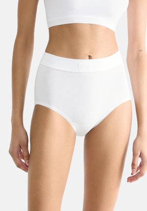 Białe figi high-waisted z gładkiego materiału z szerokim elastycznym pasem. Posiadają subtelnie falbaniasty brzeg i minimalistyczny design.