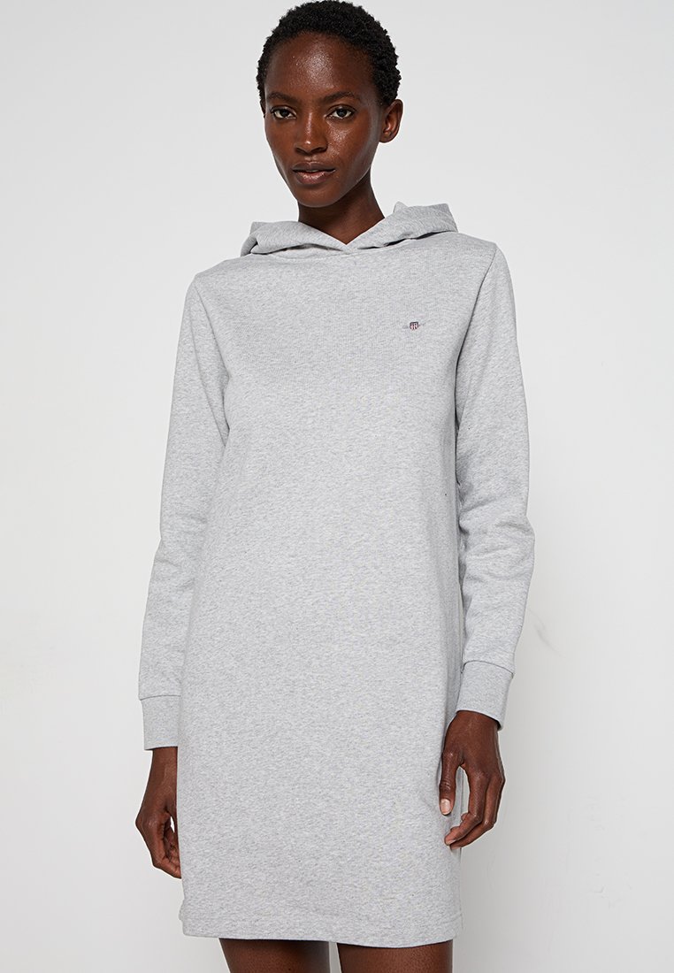 Vestido sudadera gris claro con mangas largas, fabricado en suave algodón, con un bolsillo frontal y un pequeño logo en el pecho.