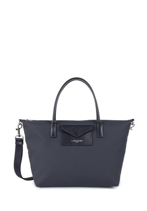 Navy nylon tote bag with leather accents, double top handles, detachable shoulder strap, and a front flap pocket featuring logo detail.