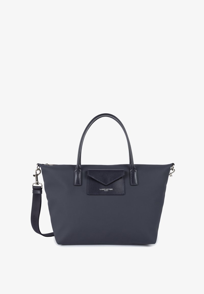 Sac fourre-tout en nylon marine avec des accents en cuir, double anses supérieures, bandoulière amovible et poche à rabat à l'avant avec détail du logo.