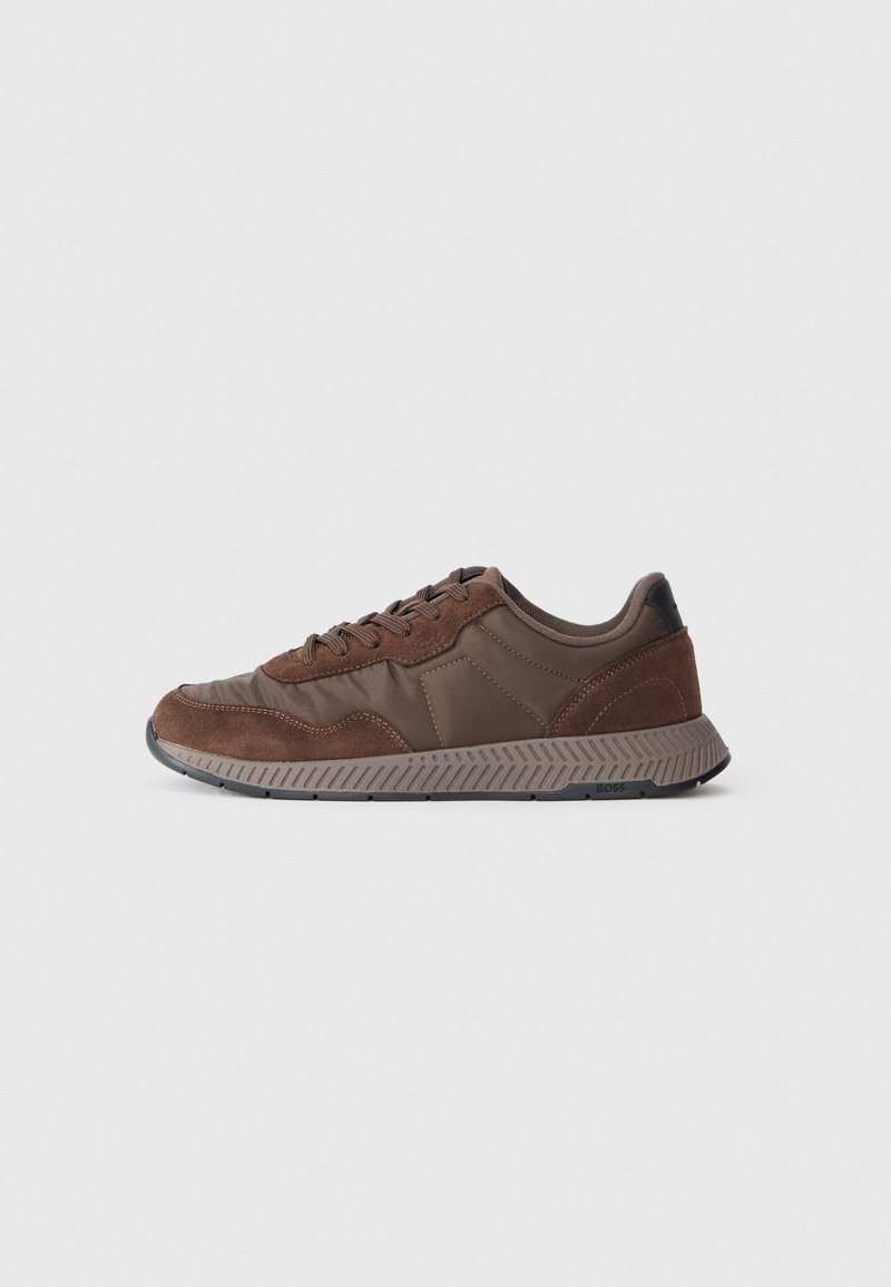 Basket marron présentant un mélange de matériaux lisses et en daim, un bout rond, une semelle en caoutchouc texturée et un accent de talon noir contrastant.