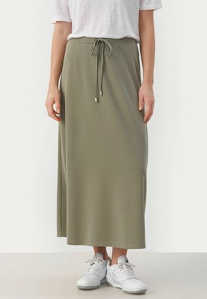 Olive green, ankle-length skirt made of soft fabric with an elastic waistband and drawstring. Paired with white sneakers.