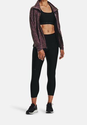 Czarny sportowy crop top oraz legginsy z wysokim stanem, a do tego strukturalna, ciemnofioletowa kurtka na zamek. Całość uzupełniają czarne sneakersy.