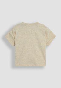 Camiseta de algodón de manga corta en color beige claro, de cuello redondo, con una textura suave y un diseño liso sin patrones ni acentos visibles.